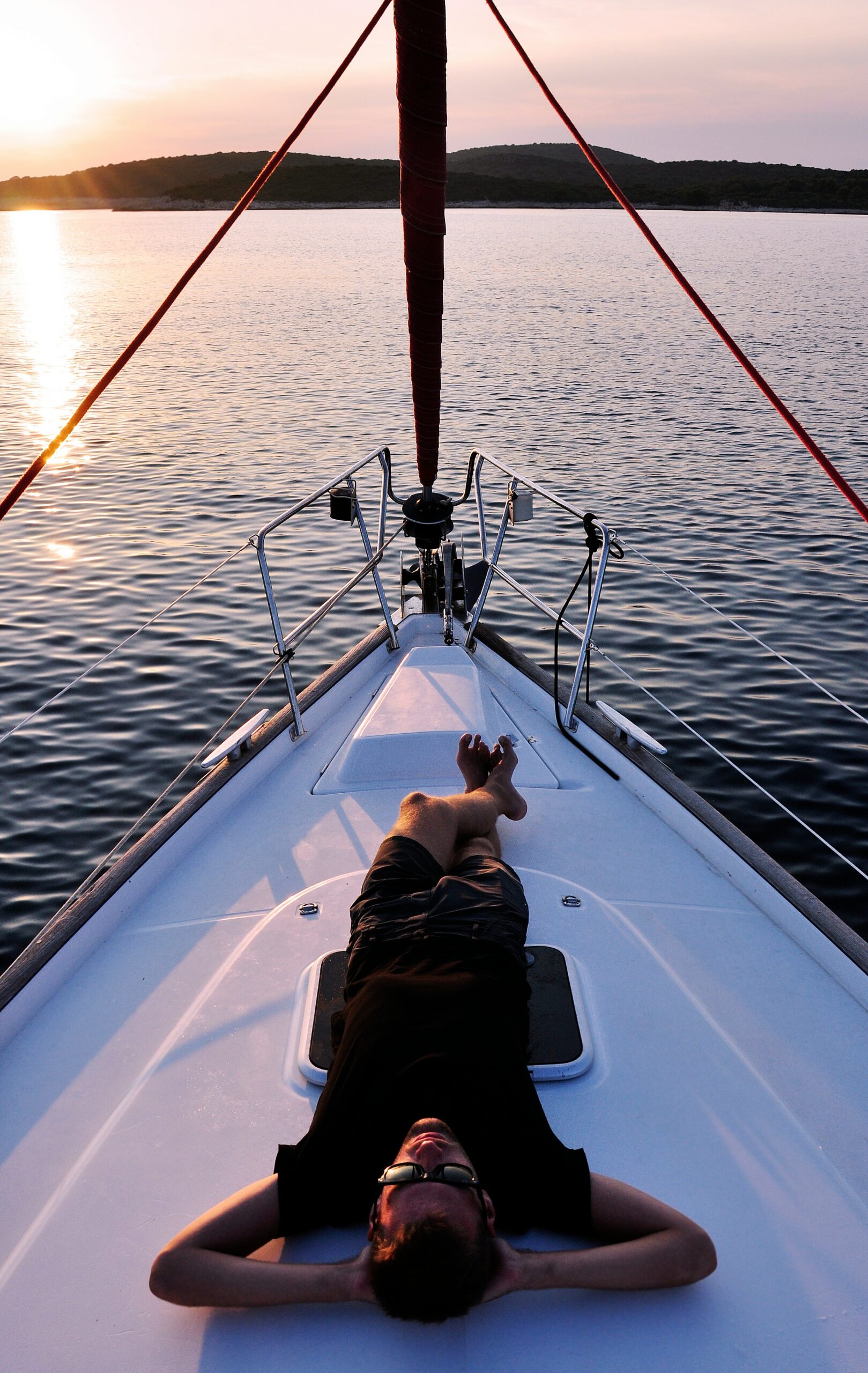 man lying on white boat